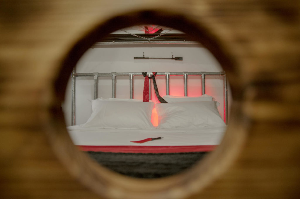 Vue par l'ouverture ronde sur le lit double dans la chambre romantique d'un hôtel près de Montpellier